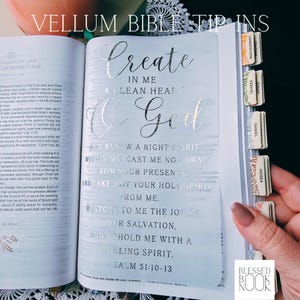 May include: A translucent vellum bible tip-in insert featuring silver foil lettering that reads Create in me a clean heart O God and Psalm 51:10-13. The insert is placed inside an open book with visible page tabs labeled Lamentations, Obadiah, Ezekiel, Jonah, Daniel, and Hosea.