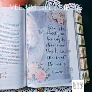 May include: A vellum Bible tip-in insert featuring a watercolor-style illustration of an angel and pink roses. The text reads: For He shall give his angels charge over thee, to keep thee in all thy ways. Psalm 91:11. The insert is placed in a Bible.
