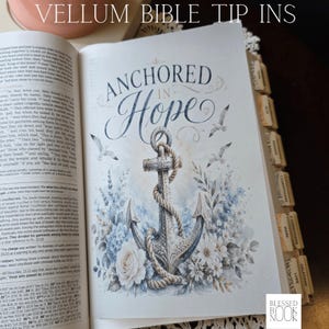 May include: A vellum bible tip-in page featuring the text Anchored in Hope above a detailed illustration of a nautical anchor wrapped in rope, surrounded by blue and white floral arrangements and flying seagulls, set within a bible with index tabs.