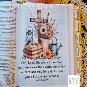 May include: A translucent vellum insert for a Bible featuring a wooden cross, a stack of books, a lantern, a watering can, and flowers. The text reads: For I know the plans I have for you, declares the LORD, plans for welfare and not for evil.