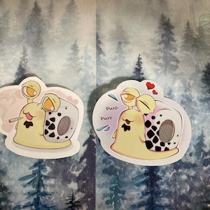 May include: Two stickers depicting cartoon snails with yellow bodies, large eyes, and black and white patterned shells. One snail has a cigarette, the other has hearts and the word "Puro".