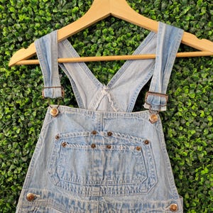 May include: A white ceramic mug with a black handle and the text "But First, Coffee" in a black, bold font. The mug is on a white surface. The mug is approximately 4 inches tall.