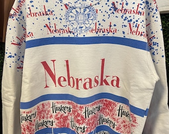 vtg 90s NEBRASKA CORNHUSKERS AOP Crewneck Medium // vintage white red blue black art ncaa sweatshirt pullover university crest splatter