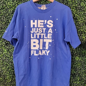 Camiseta promocional vintage SNOWMAN SNOWDEN TARGET, talla extragrande, algodón azul, con la frase "He's just a little bit flakey", de Target, para las fiestas navideñas de los años 90.