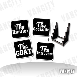 Puede incluir: Cuatro pegatinas cuadradas negras con texto blanco: "The Hustler", "The Socialite", "The GOAT" y "The Introvert". También se incluye un expositor de madera negro. Las pegatinas y el expositor están sobre un fondo blanco.