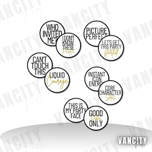 Puede incluir: Un conjunto de accesorios circulares en blanco y negro con detalles dorados y frases como "Who Invited Me?" y "Good Vibes Only". Estos accesorios están diseñados para fiestas y eventos.