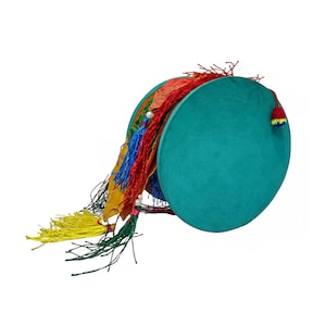 Puede incluir: Un tamborín turquesa con borlas coloridas. El tambor tiene forma circular con una superficie turquesa. Las borlas son en tonos rojos, amarillos, azules y verdes. Una pequeña borla roja y amarilla está en el lateral.