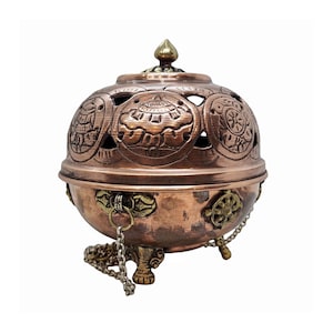 May include: A copper-colored incense burner with intricate etched designs and a decorative lid. The spherical body features cut-out patterns and is supported by three small feet. A chain and decorative accents add detail.