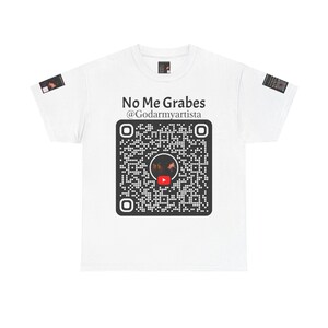 May include: White t-shirt featuring the text "No Me Grabes @Godarmyartista" above a large QR code. The QR code has a YouTube logo in the centre. Small rectangular patches are on the sleeves.