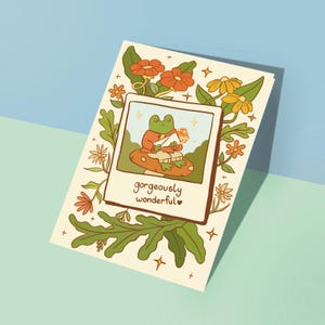 Tarjeta de felicitación maravillosa y acogedora, dibujada a mano, de calidad, con diseño de rana floral y terroso, "Pensando en ti", descargable digitalmente.