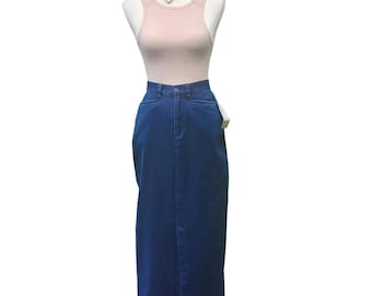 May include: A mannequin displays a light pink tank top and a dark blue denim skirt. The skirt is a long, pencil style with a front slit. A silver necklace with a heart pendant is visible.