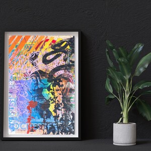 May include: A framed abstract art print with a collage of colorful geometric shapes, lines, and patterns. The print is in a black frame and is hanging on a black wall.