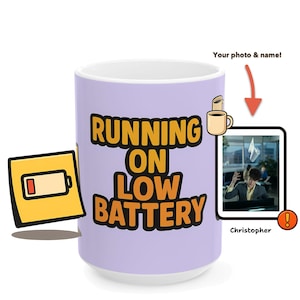 May include: A light purple ceramic mug with the text "RUNNING ON LOW BATTERY" in orange and black. A cartoon image of a low battery is on the left. A small photo of a person is on the right, with the name "Christopher" below.