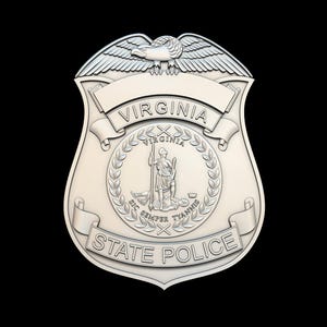 Może przedstawiać: Srebrna odznaka policji stanowej Wirginii. Odznaka przedstawia orła na górze, napis "VIRGINIA" pośrodku i "STATE POLICE" na dole. Centralny emblemat przedstawia osobę trzymającą laskę.