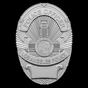 May include: A silver-coloured Los Angeles Police Officer badge. The badge features the words "POLICE OFFICER" at the top and "LOS ANGELES POLICE" at the bottom. The centre design includes a building and the city seal.