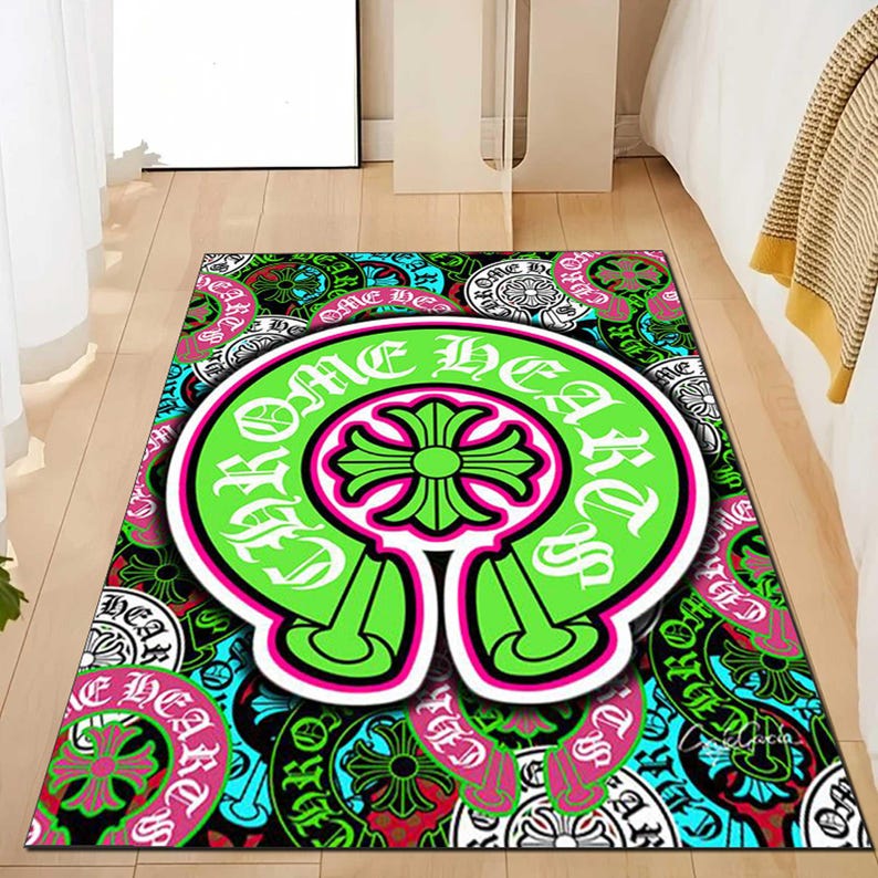 May include: A rectangular area rug with a vibrant, repeating pattern. The rug features a large, neon green emblem with the words "Chrome Hearts" in white, and a pink outline. The background is a mix of teal, black, and pink designs.