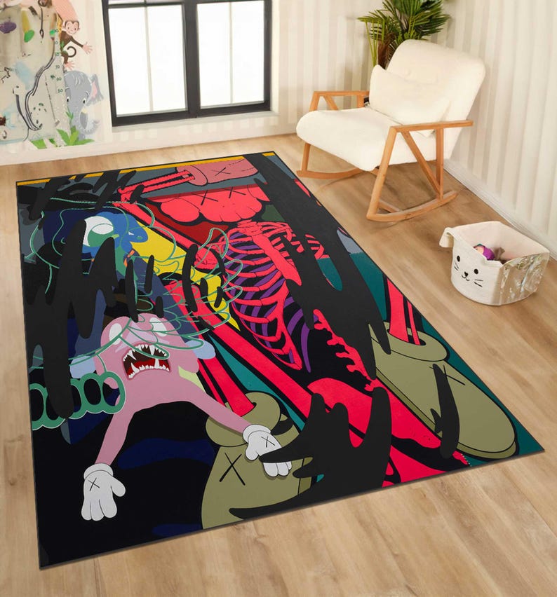 May include: A large rectangular area rug with a colorful, abstract design. The rug features a pink cartoon figure with white gloves, a red skeleton, and black, green, and blue shapes against a black background. The rug is placed on a wooden floor.
