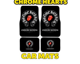May include: Black car mats with the text "CHROME HEARTS" in yellow. The mats feature a white design with a red tongue logo. The words "CAR MATS" are also in yellow.