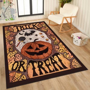 May include: A rectangular Halloween-themed rug with a dark brown border. The rug features a jack-o'-lantern, a bat, stars, and the words "TRICK OR TREAT" in a bold font. The design includes spiderwebs and candy corn.