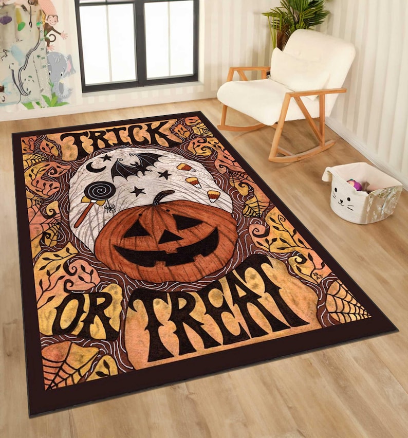 May include: A rectangular Halloween-themed rug with a dark brown border. The rug features a jack-o'-lantern, a bat, stars, and the words "TRICK OR TREAT" in a bold font. The design includes spiderwebs and candy corn.