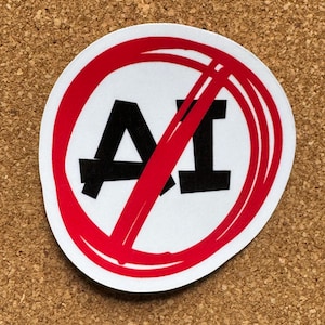 Op de afbeelding: Een ronde sticker met de zwarte tekst AI gecentreerd op een witte achtergrond. Een dikke rode cirkel met een diagonale streep loopt door het midden en streept de letters door. Het ontwerp is strak met een witte rand om de rode afbeelding.