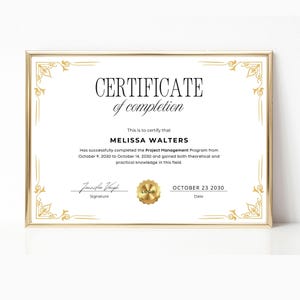 May include: A framed certificate of completion with gold accents. The certificate has the text "CERTIFICATE of completion" and the name "MELISSA WALTERS". The date on the certificate is October 23, 2030.