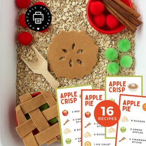 Peut inclure: Un bac sensoriel sur le thème de la tarte aux pommes. Comprend des morceaux de tarte aux pommes en feutrine, des pompons rouges et verts, des bâtons de cannelle et des fiches de recettes. Les cartes indiquent "Apple Crisp" et "Apple Pie" avec 16 recettes.