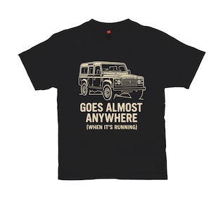 May include: Black t-shirt featuring a beige illustration of a four-wheel drive vehicle. The text "GOES ALMOST ANYWHERE (WHEN IT'S RUNNING)" is printed below the vehicle in a bold font. The shirt is made of a soft material.