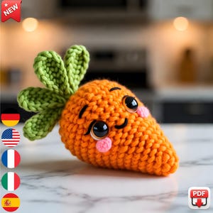 Op de afbeelding: Een gehaakte oranje wortel met groene bladeren, zwarte ogen en roze wangen. De wortel heeft een lachend gezicht en is waarschijnlijk een handgemaakt speelgoed of decoratie. Een "NIEUW"-badge staat linksboven.