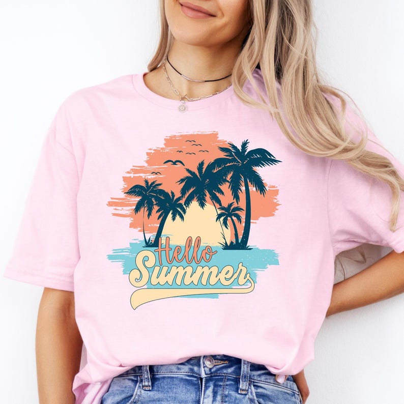 K&ouml;nnte beinhalten: Hellrosa T-Shirt mit tropischem Design. Die Grafik zeigt Palmen, V&ouml;gel und den Text "Hello Summer" in einer verspielten Schriftart. Das Design ist vor einem Hintergrund aus Orange-, Blau- und Gelbt&ouml;nen gehalten.