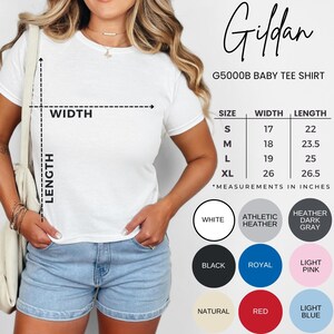 May include: A white Gildan G5000B baby tee shirt. The shirt has a crew neck and short sleeves. Size chart shows measurements in inches. Available colors include white, black, and red.