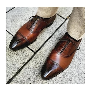 Handgjorda herrskor i brunt läder med Oxford Brogue-detaljer och snörning, klassiska tåskor