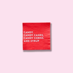 May include: Red paper napkin with white text that reads "CANDY, CANDY CANES, CANDY CORNS, AND SYRUP".