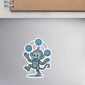 May include: A sticker depicting a cartoon monkey juggling three blue orbs with binary code. The monkey is grey with a white outline, and the orbs have a binary code design. The sticker is on a laptop.