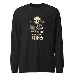 Può includere: Maglietta nera a maniche lunghe con uno scheletro con le cuffie e che codifica su un laptop. Il testo recita "TOO BUSY CODING TO TRICK OR TREAT" con grafica di caramelle. Una maglietta grafica a tema Halloween.