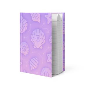May include: A hardback notebook with a purple gradient cover. The cover has a repeating pattern of seashell and circuit board designs. The notebook's pages are lined and visible on the right. The cover design includes white seashell and circuit board illustrations.