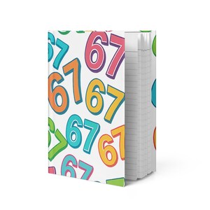 May include: A spiral-bound notebook with a white cover featuring a colorful pattern of the numbers 6 and 7. The numbers are in various colors, including orange, blue, yellow, and pink. The notebook's pages are lined.