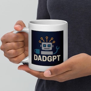 May include: White ceramic mug featuring a robot design with the text "DADGPT" in white. The robot has a square head, a wrench, and a small cup. The background is dark blue with yellow and orange accents.