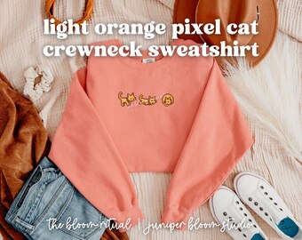 Jasnopomarańczowa, przytulna bluza z okrągłym dekoltem i motywem kota pikselowego | przytulny prezent dla graczy
