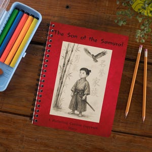 May include: A red spiral-bound notebook titled "The Son of the Samurai" with an illustration of a young boy in traditional Japanese attire. A light blue pencil case with colorful markers and an eraser, and two pencils are also on the wooden surface.