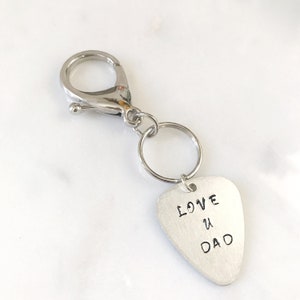 May include: Silver keychain with a guitar pick charm that says "LOVE U DAD".