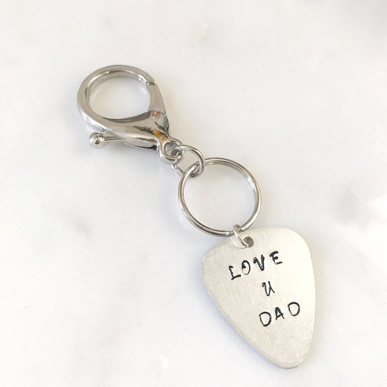 May include: Silver keychain with a guitar pick charm that says "LOVE U DAD".