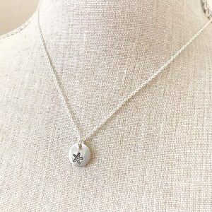 May include: A silver chain necklace with a small silver pendant featuring a starfish design.