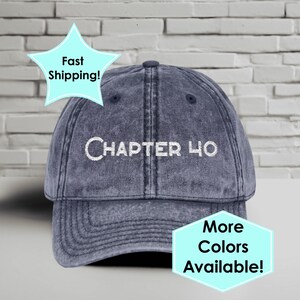 May include: A blue baseball cap with the embroidered text "CHAPTER 40" in white. The cap has a curved brim and a button on top. The image also includes text that says "More Colors Available!"