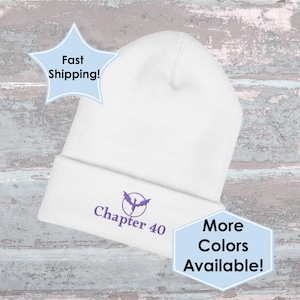 May include: White beanie hat with a turned-up brim. The hat has a purple embroidered design and the text "Chapter 40". The image also includes text that says "More Colors Available!"