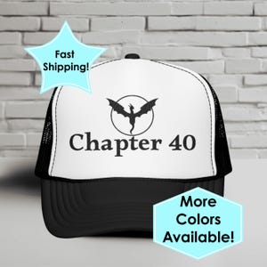 May include: Black and white trucker hat featuring a dragon emblem and the text "Chapter 40". The hat has a black peak and mesh back. The image also includes the text "More Colors Available!" and "Fast Shipping!"