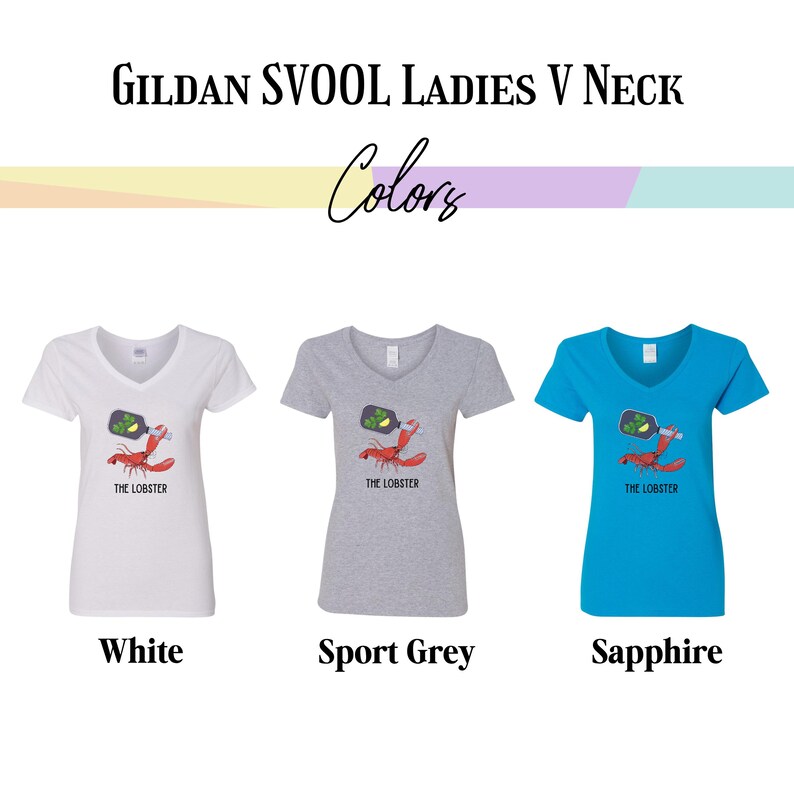 May include: Three Gildan SVOOL Ladies V Neck t-shirts in white, sport grey, and sapphire blue. Each shirt features a graphic of a lobster holding a bottle with the text "THE LOBSTER" below the graphic. The word "Colors" is above the shirts.