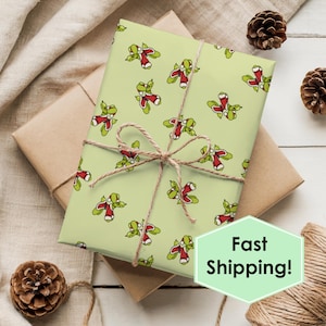 May include: A wrapped gift with light green wrapping paper featuring a repeating pattern of green and red cartoon characters. The gift is tied with twine and has a light brown paper underneath. The text "Fast Shipping!" is on a green hexagon.