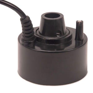 May include: A black ultrasonic mist maker with a cylindrical base and a central nozzle. A black power cord extends from the side. A small, vertical post is on the right side of the device. The device is designed to create mist.