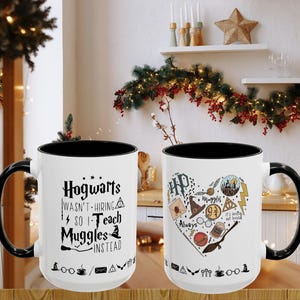 May include: Two white ceramic mugs with black handles and rims. One mug has the text "Hogwarts wasn't hiring so I teach Muggles instead" in black. The other mug features a heart-shaped design with Harry Potter-themed illustrations.